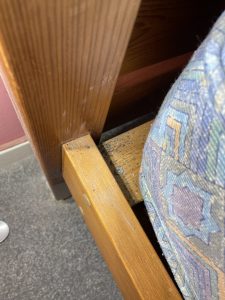 Fecal spotting and bed bug stains uncovered on a wooden bed frame during removal.